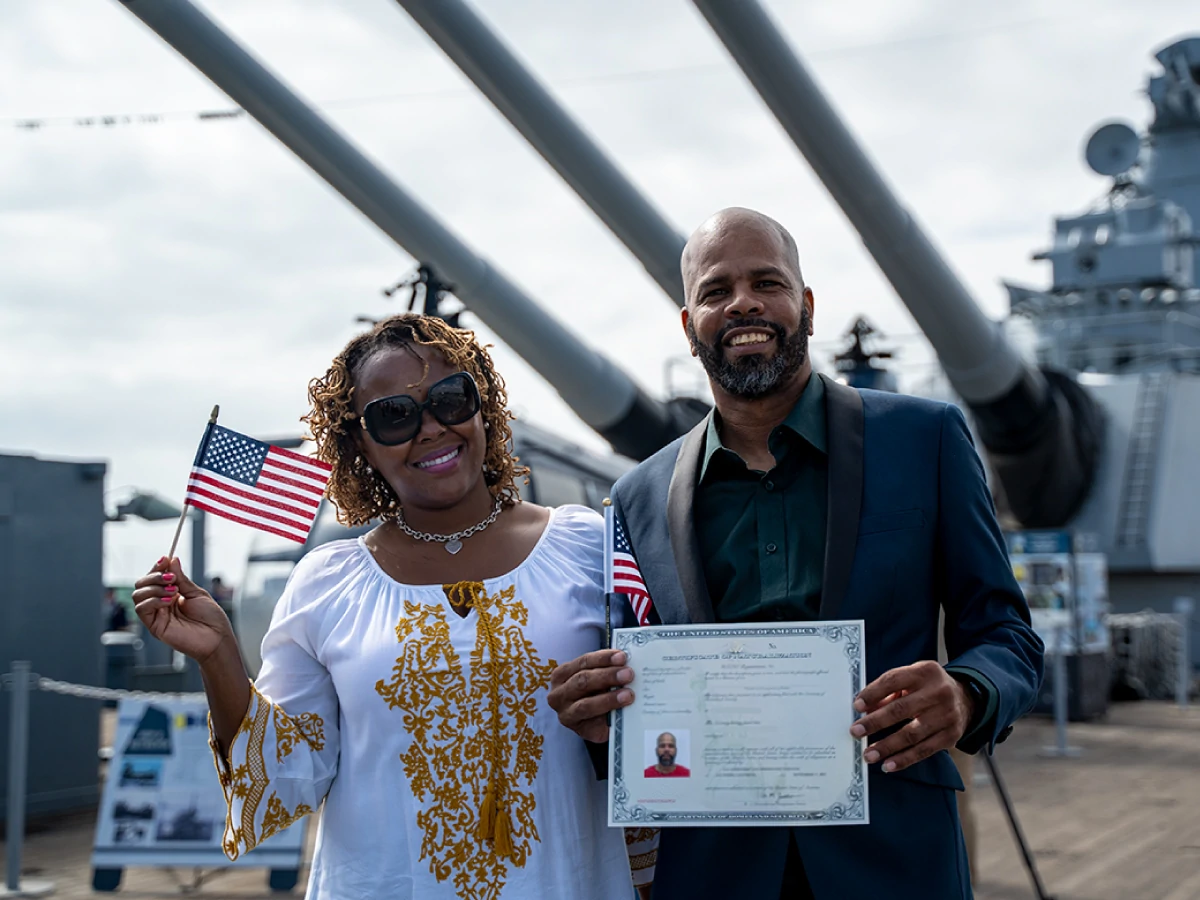 Happy new US citizen holding their naturalization certificate after completing the naturalization process.