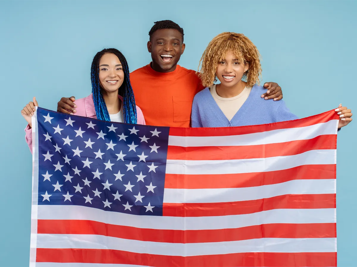 Three siblings holding a US flag, representing the process behind the question: can US citizen sponsor siblings?