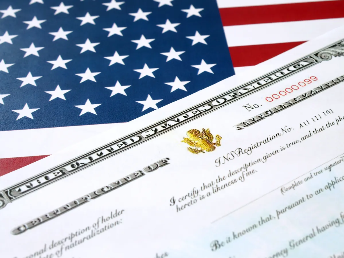 US citizenship naturalization certificate next to an American flag
