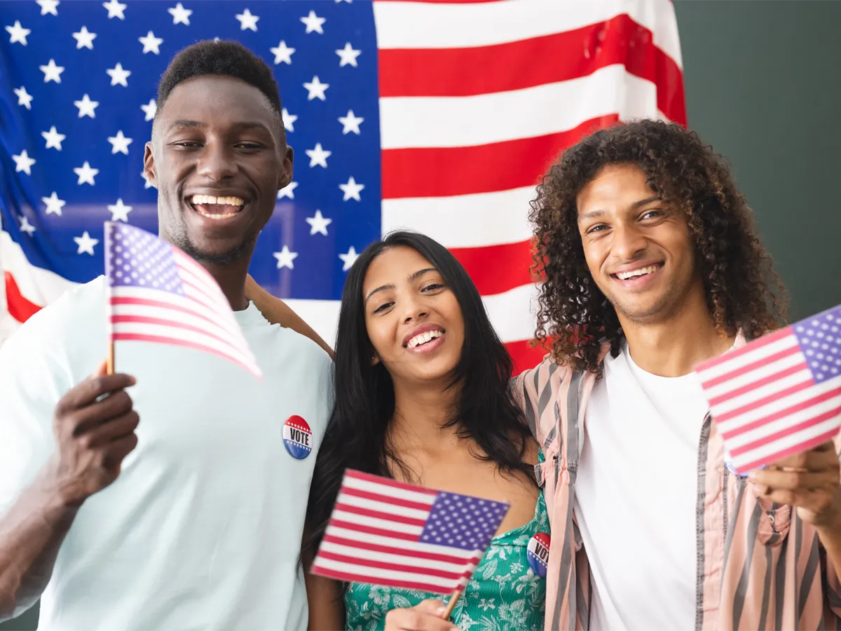 Why Is US Citizenship Important? Three smiling applicants with American flag