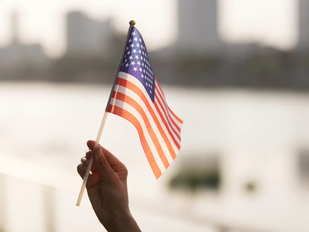 N-400 applicant holding a US flag, symbolizing steps to avoid delays in the citizenship process
