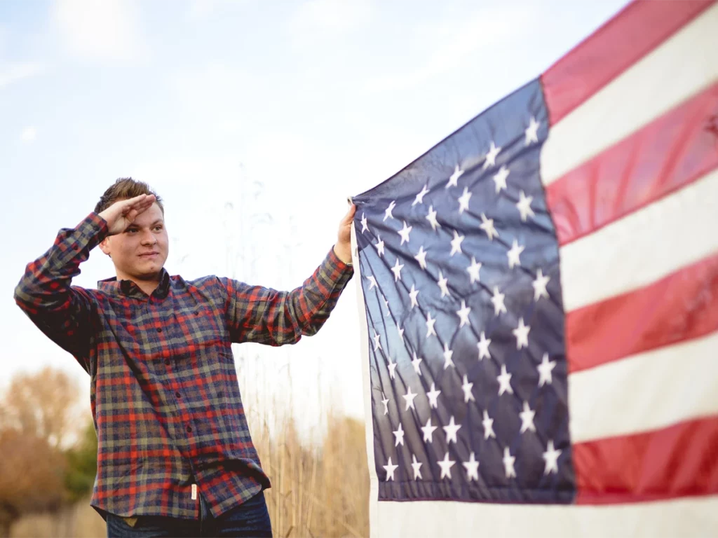 Selective Service for naturalization An applicant holding an American flag for Selective Service registration.