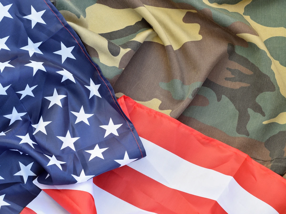 US military uniform next to the American flag symbolizes Selective Service obligations for citizenship.