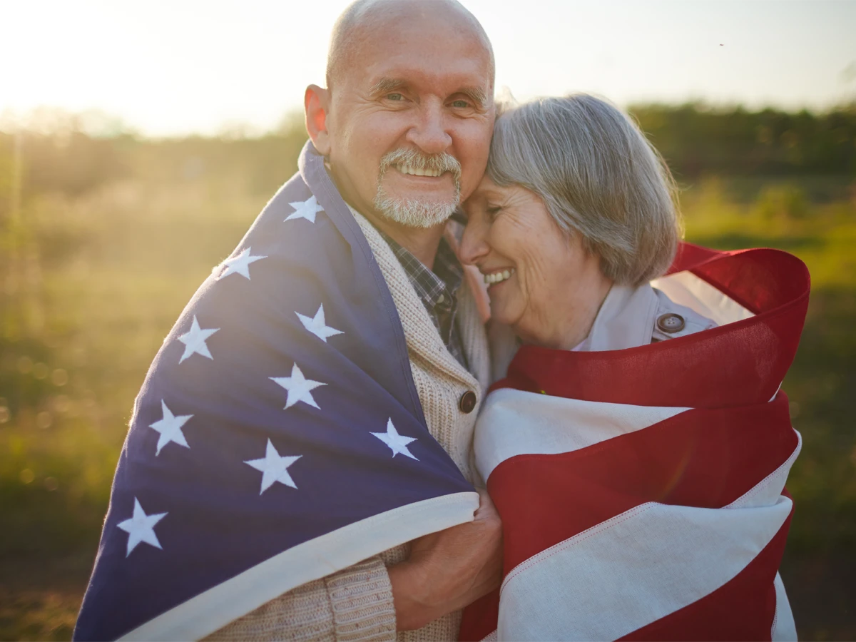 Applicants applying for citizenship with the American flag, benefiting from the USCIS 65/20 rule for US Citizenship Test Questions for Seniors.