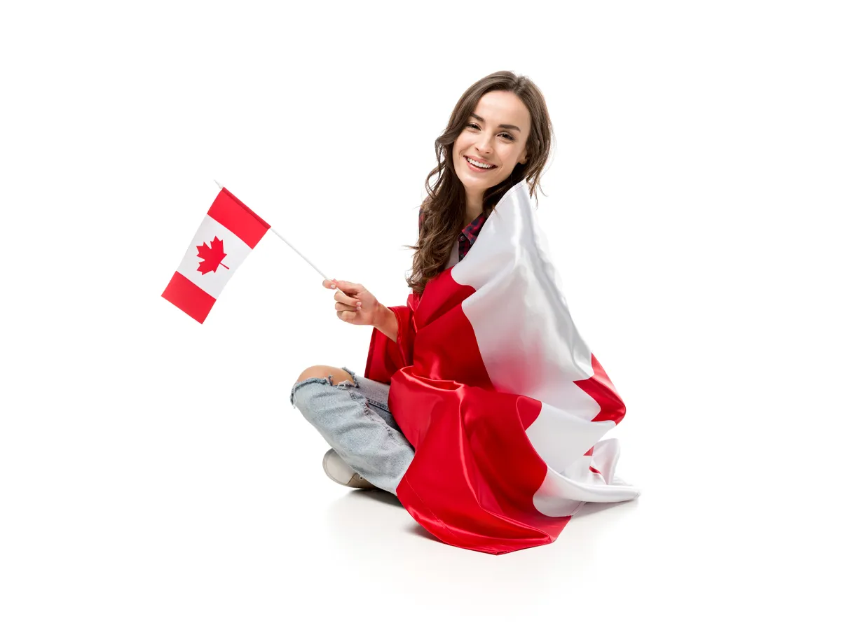 Smiling applicant holding a Canadian flag while studying how to pass the Canadian citizenship test.