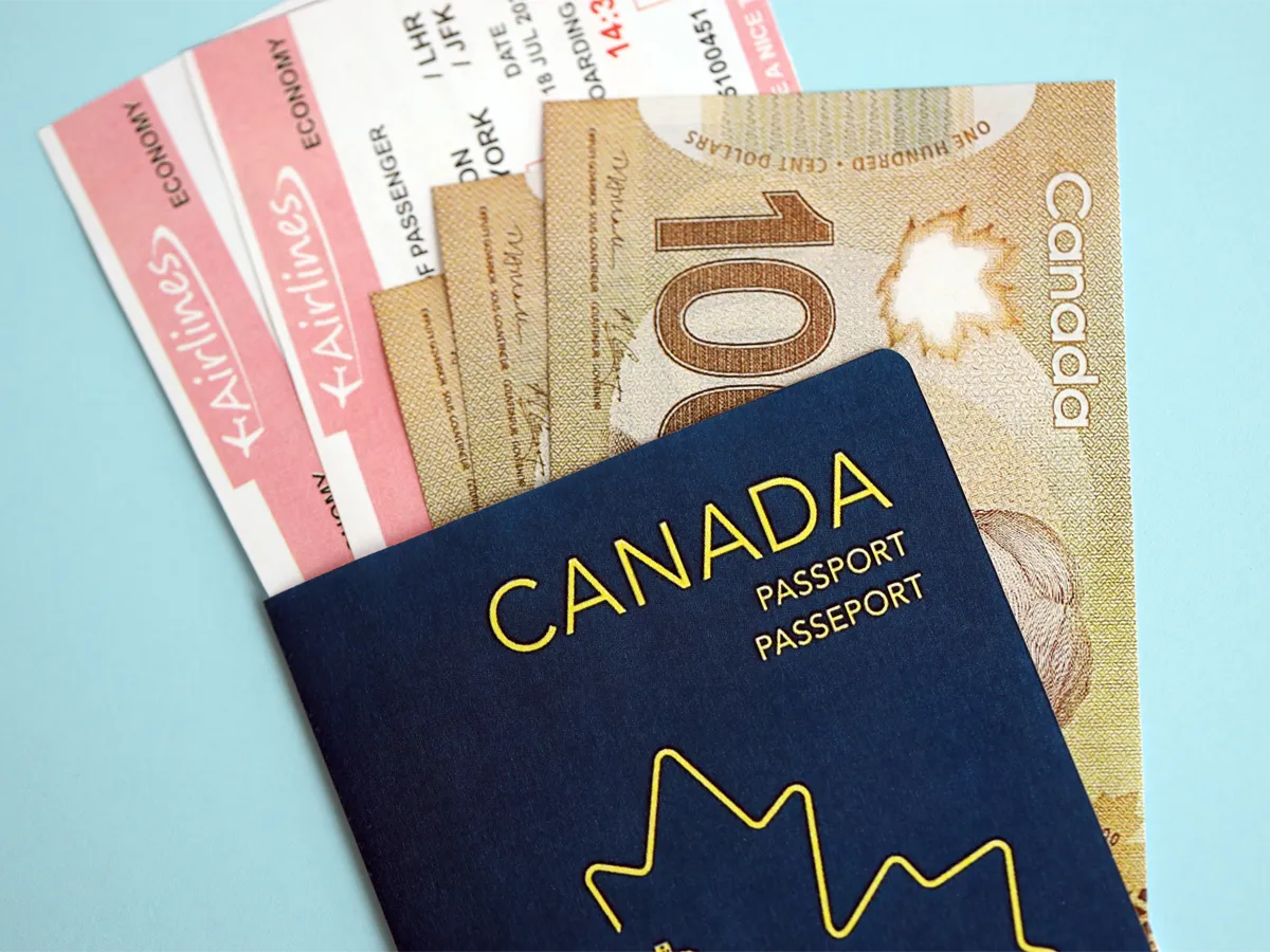 Canadian passport cost illustrated with a Canadian passport and money representing application fees